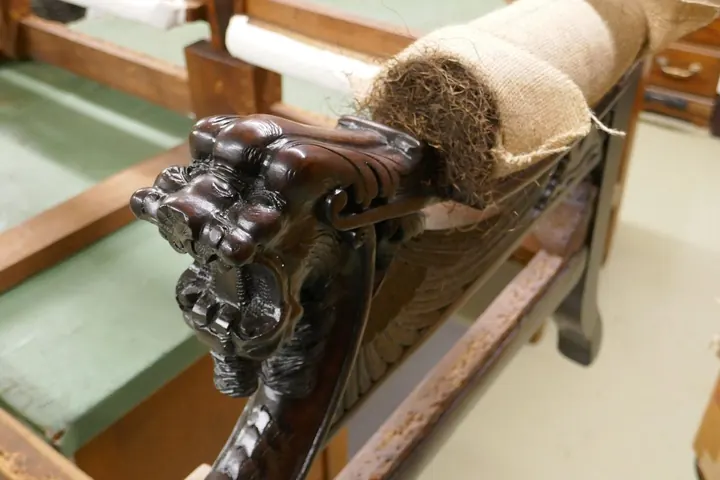 The first step in padding the arms is shaping Spanish moss into a roll of burlap.