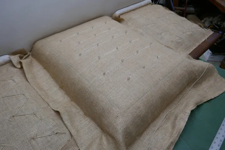 Temporary staples holding burlap in place for stitching.