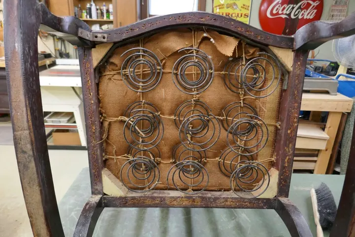The original burlap was patched together with seat webbing over the existing tying.