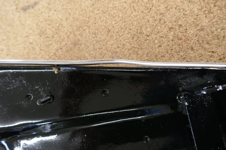 Aluminum trim being straightened and fit against the pan.